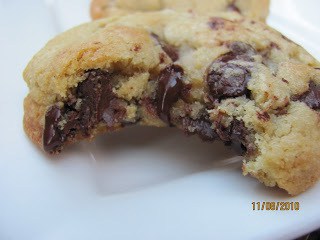 A close up of a chocolate chip cookie with a bite removed