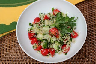 Overhead view of tabbouleh recipe in a white bowl garnished with parsley