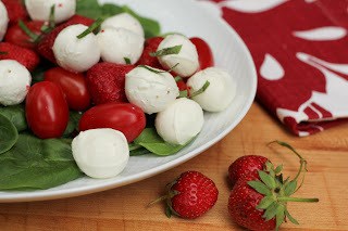 White oval platter of mozzarella, tomato and strawberry salad