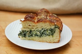 Slice of spinach tart on a white plate.