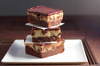 A stack of cookie dough brownies on a white plate