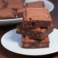 Stack of caramel brownies on a round white plate