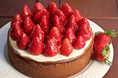 strawberry topped cheesecake on a white plate