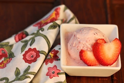 Close view of a scoop of strawberry mascarpone ice cream in a square white bowl