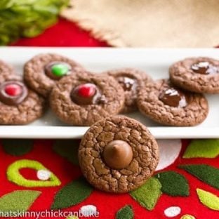 Double Chocolate Thumbprints on a white tray with one cookie perched in front