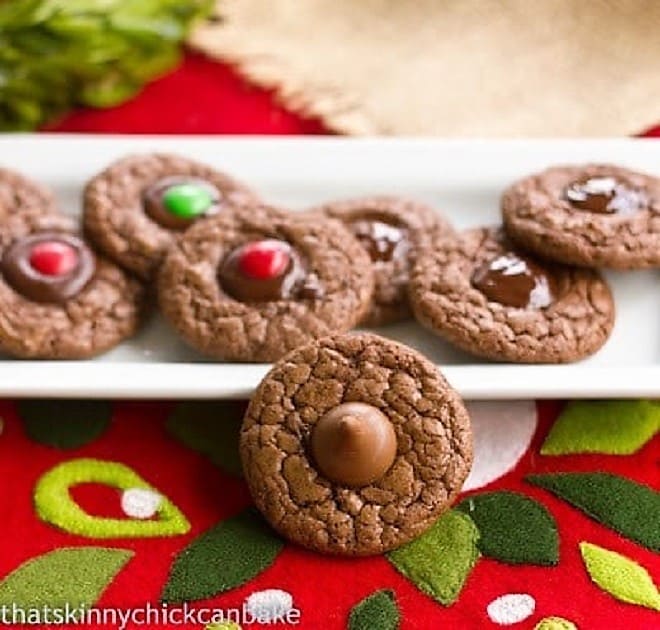 Double Chocolate Thumbprints on a white tray with one cookie perched in front.