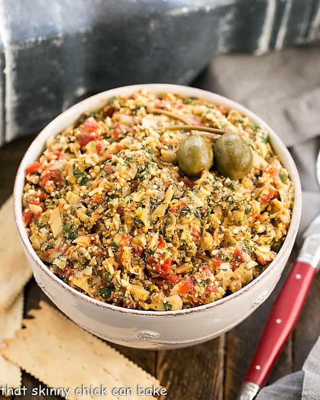 Overhead view of this artichoke tapenade with a red handled spoon