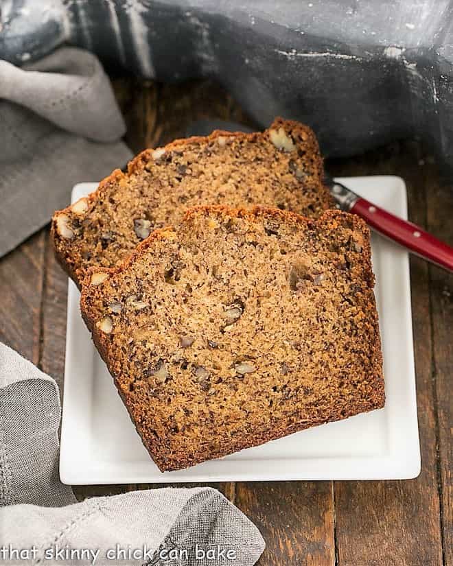 Two slices of the best banana bread on a square white plate