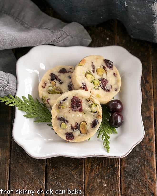3 Cranberry Pistachio White Chocolate Shortbread Cookies on a square white plate