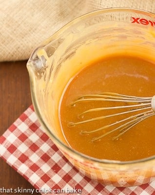 A glass measuring cup filled with warm white chocolate ganache