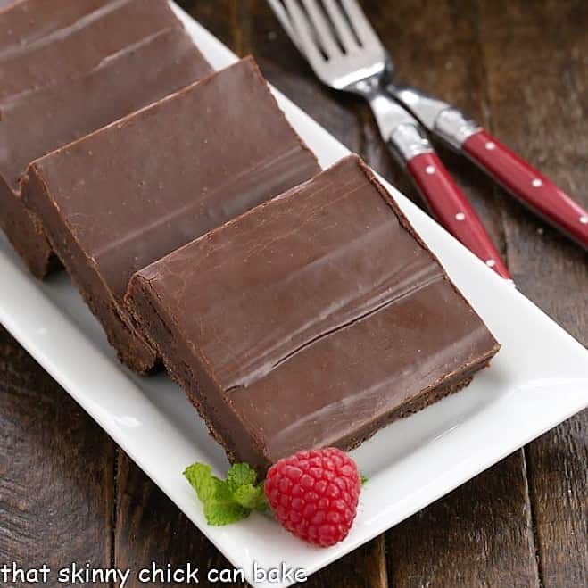 view of 3 fudgy brownie squares on a white ceramic tray.