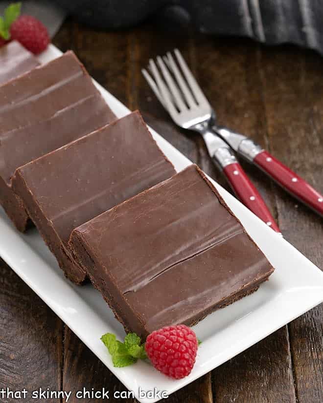 Fudge topped brownie squares on a platter.