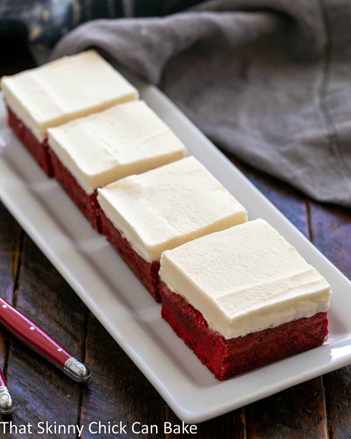 3 red velvet brownies on a white ceramic tray.