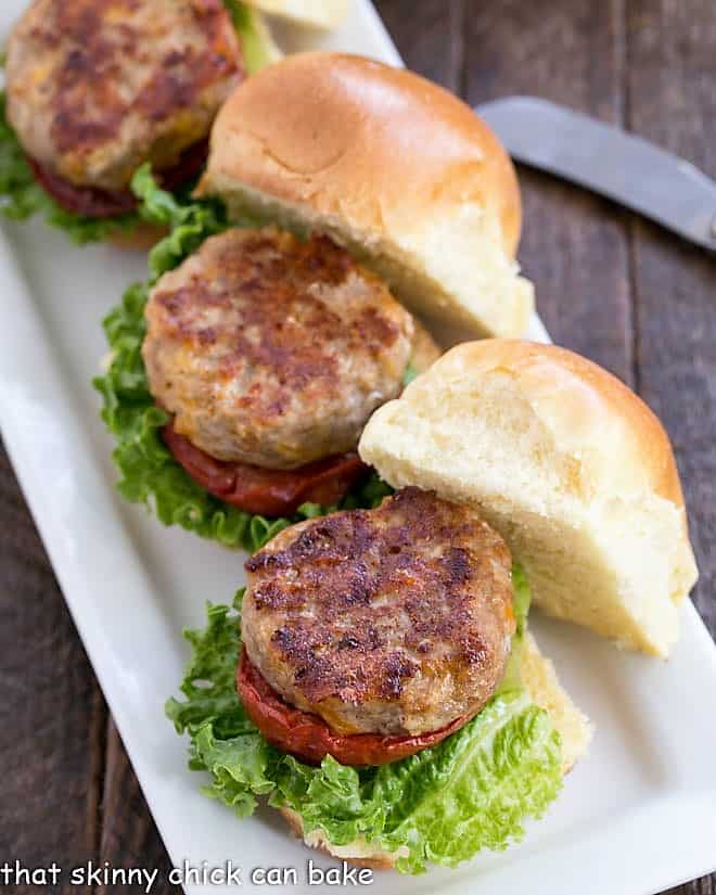 Turkey Sliders with Roasted Tomatoes lined up on a white serving tray