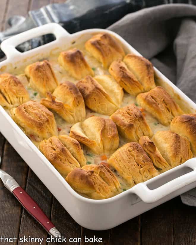 Chicken Pot Pie in a whiite casserole dish topped with butterflake biscuits