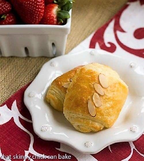 Homemade Classic Croissants filled with almond paste on a white plate.