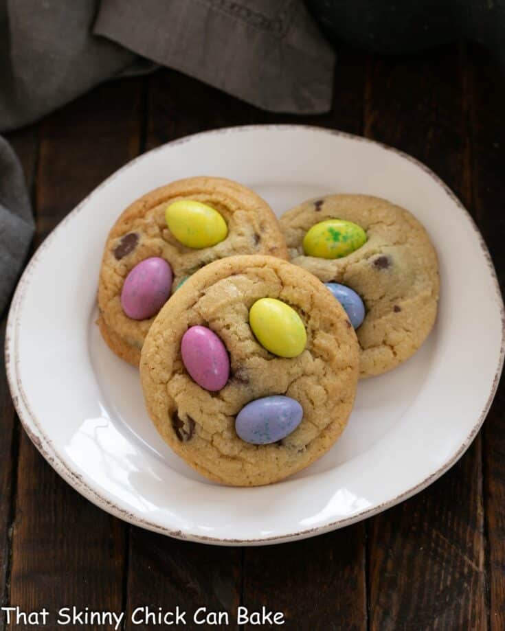Overhead view of 3 Easter M&M Cookies on a white plate.