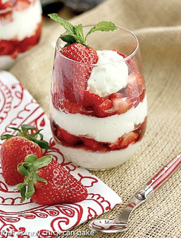 Strawberry Parfaits with a red handled spoon, red and white napkin and fresh strawberries.