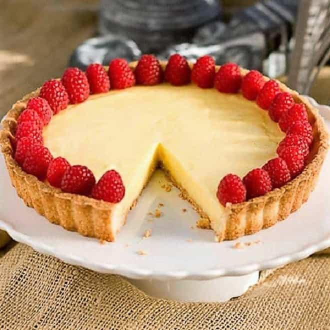  Tarte au Citron AKA French Lemon Tart on a cake stand with a slice removed.