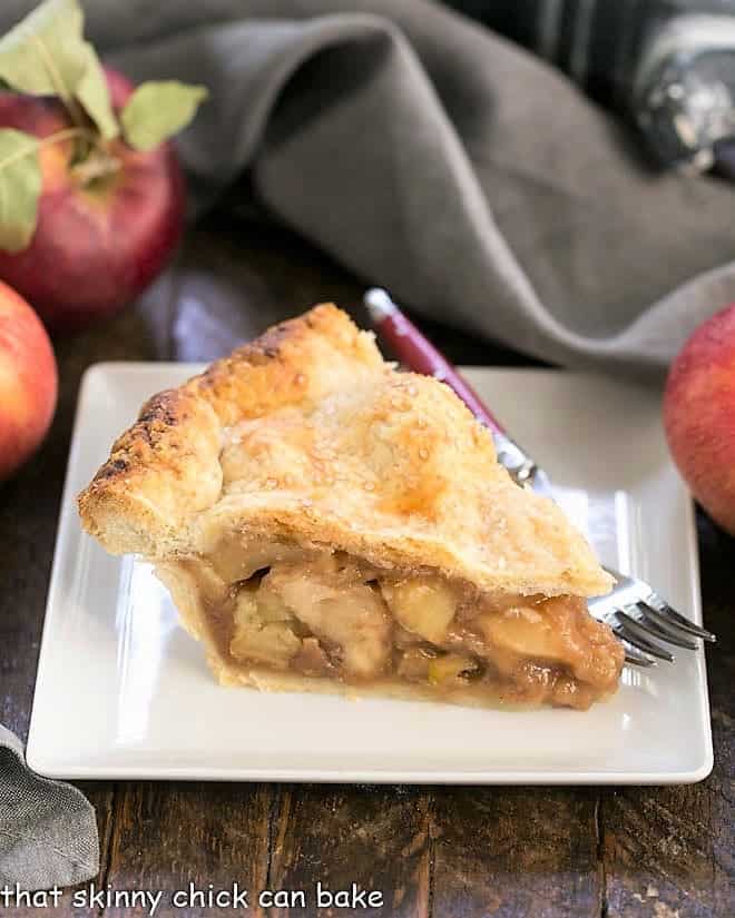 Slice of caramel apple pie on a square white plate