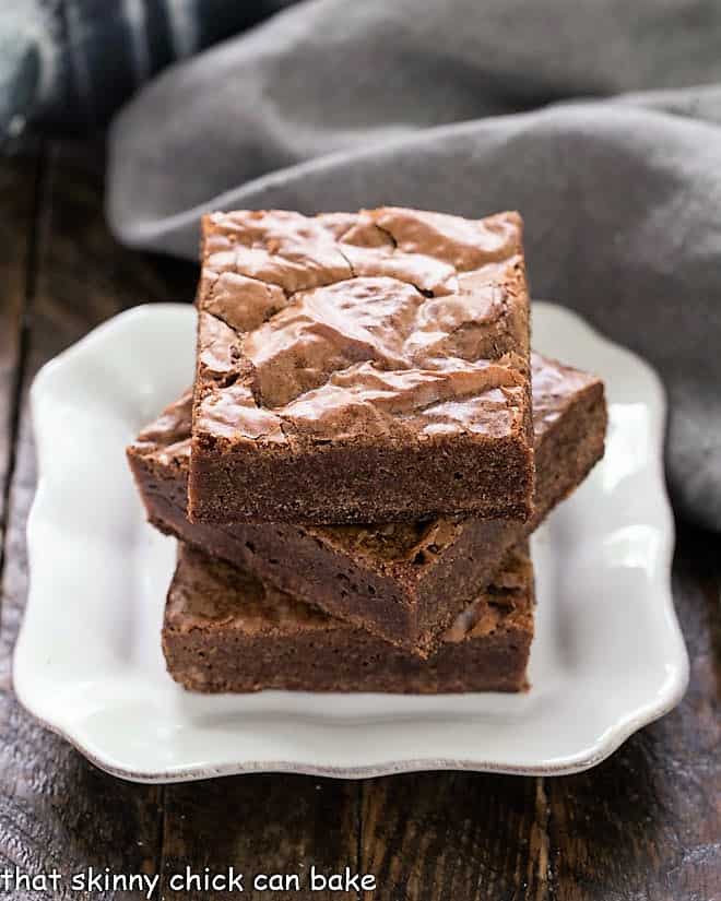 Easy Homemade Brownies stacked on a white plate.