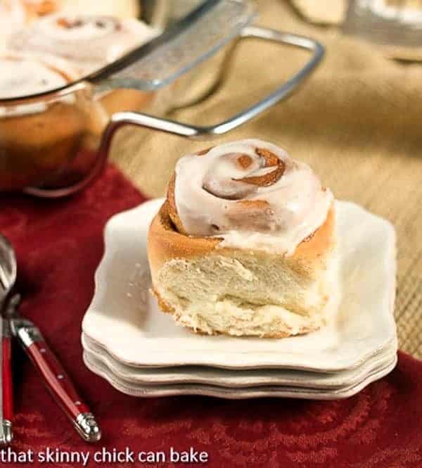 Moomies Cinnamon Buns on a stack of small white plates.