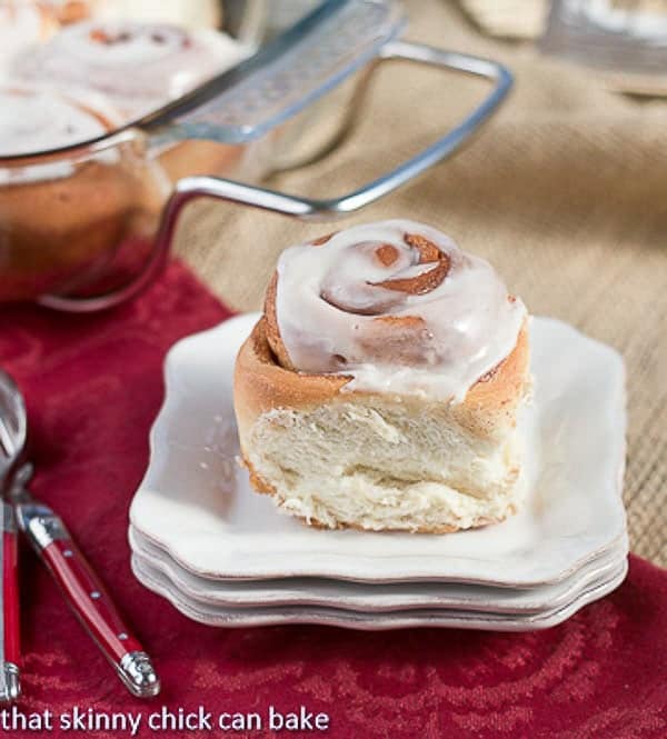 Moomie's Cinnamon Buns on a stack of small white plates with red handle forks