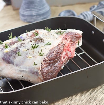 Glazed Leg of Lamb with Garlic and Rosemary in a roasting pan.