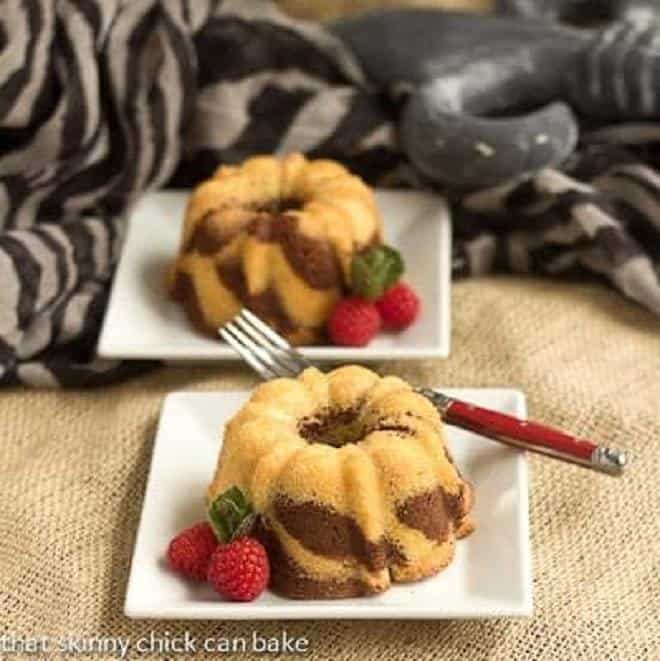 Two Mini Zebra Bundt Cakes on square white dessert plates.