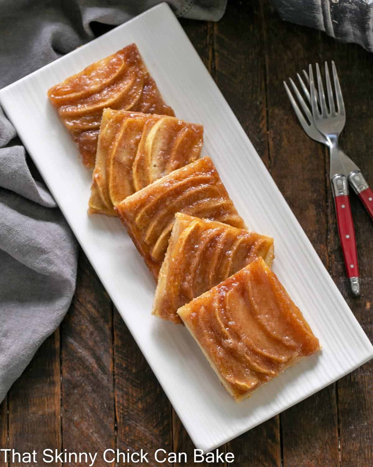 White platter with squares of apple kuchen.