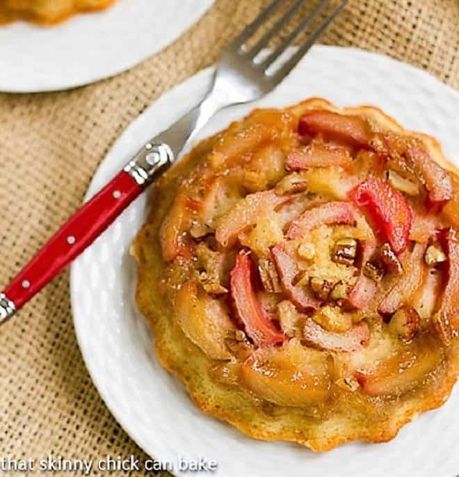 Fresh Rhubarb Upside-down Baby Cakes on a white dessert plate with a red handled fork