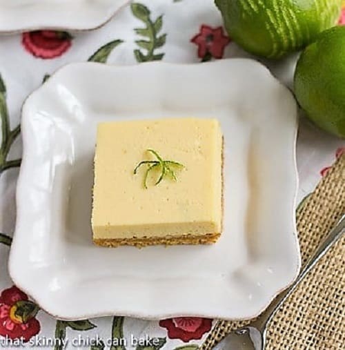 Overhead view of square of key lime pie bars on a white plate