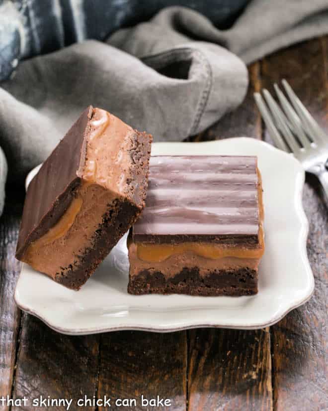 2 milky way brownies on a square white plate.