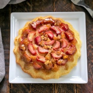 Overhead view of a rhubarb baby cake on a square white plate