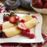 Brown Butter Crêpes with Berry and Cheesecake Filling on a square, wavy white plate