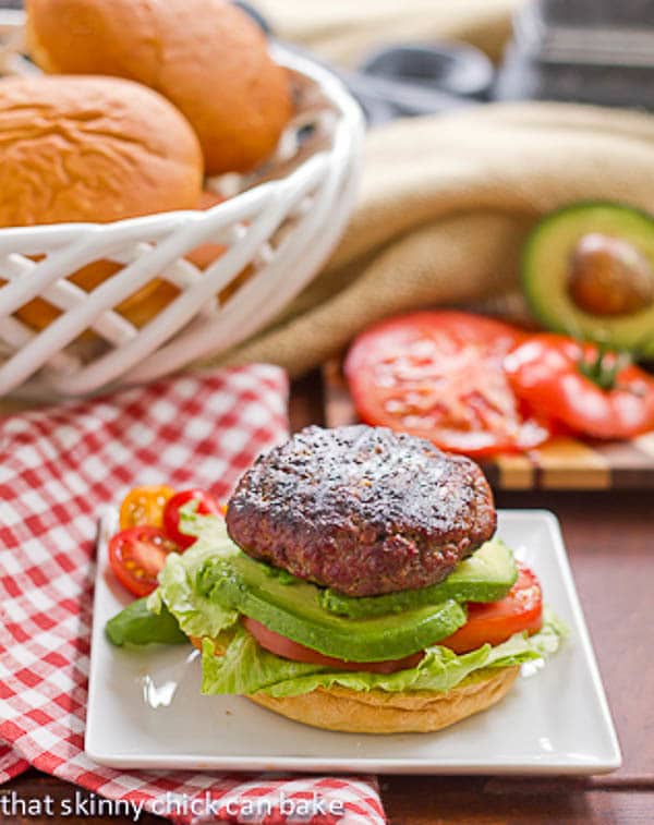 California Burgers on a plate on a red and white checked napkin.