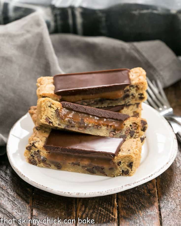 3 caramel filled chocolate chip cookie bars on a round white plate