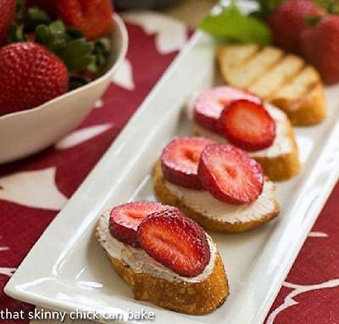 Strawberry Tartines lined up on a white platter.