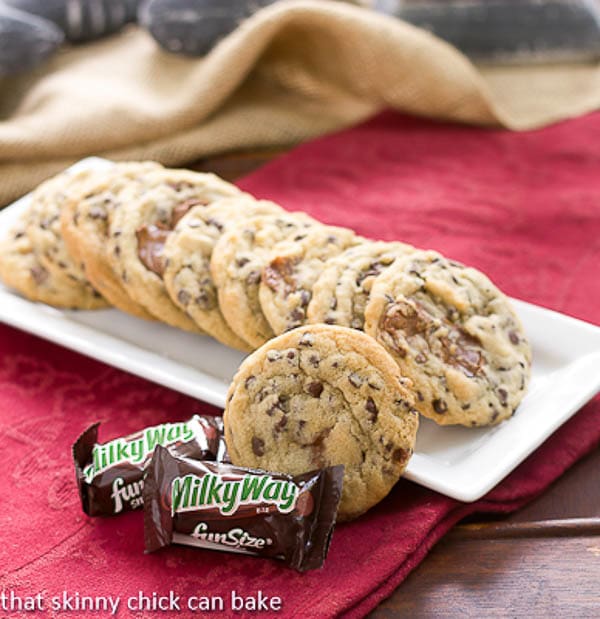 Milky Way Chocolate Chip Cookies on a white tray with fun sized Milky Way bars