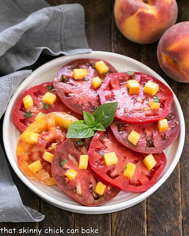 Overhead view of Tomato Salad with Peach and Basil Vinaigrette on a white plate
