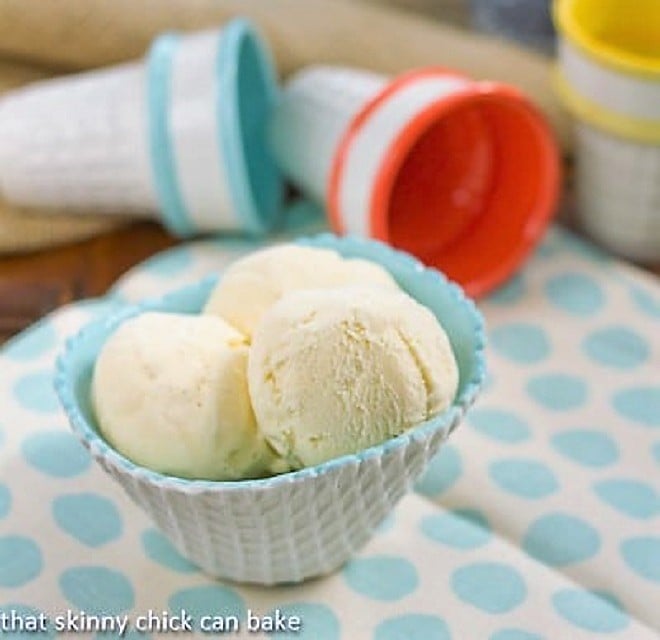 Vanilla Bean Ice Cream in a white and turquoise ice cream bowl on a polka dot napkin.