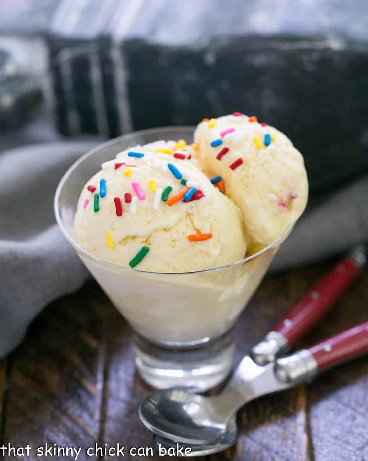 2 scoops of cake batter ice cream in a glass dish.