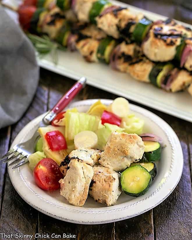 Feta Chicken Kabobs with a salad on a white plate.