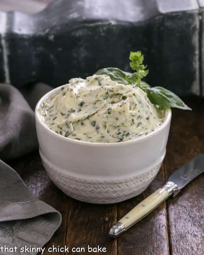 Basil butter in a white bowl with a small knife
