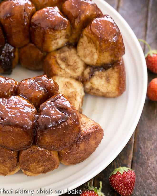 Overhead view of homemade monkey bread on a white plate with a few rolls removed.