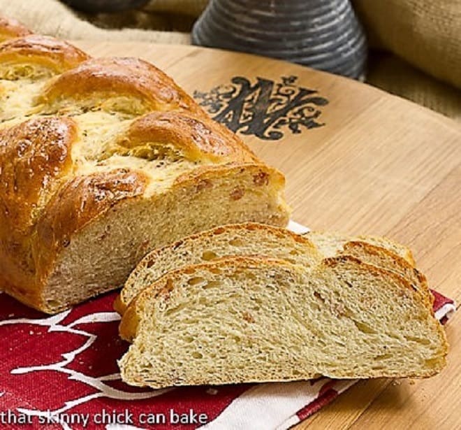 Parmesan Prosciutto Bread on a wooden board under a red and white napkin.