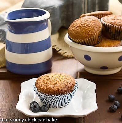 Sour Cream Blueberry Muffins in a polka dot ceramic bowl with one on a small white plate