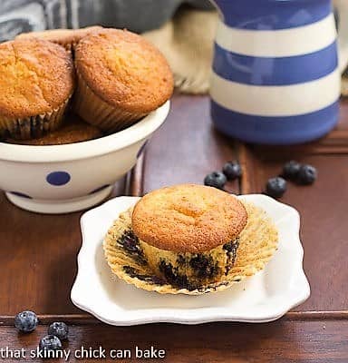  Sour Cream Blueberry Muffins on a white ceramic plate with the paper wrapper removed