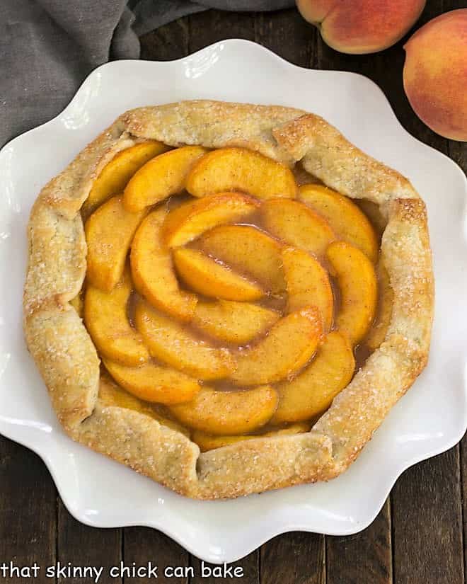 Overhead view of a Rustic Peach Galette on a ruffled white serving plate.