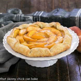 Peach galette on a white cake stand